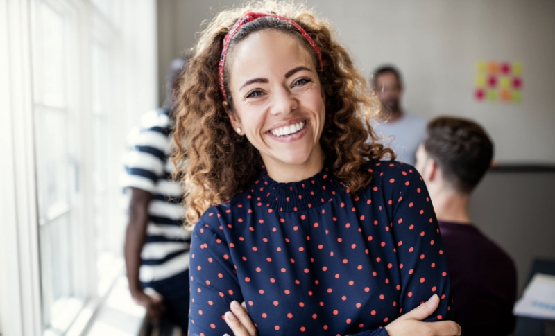 women in blue top with arms crossed, smiling while looking at the camera women in blue top with arms crossed, smiling while looking at the camera